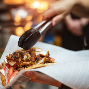 Service worker at gyros, donner restaurant, preparing one for pita bread Service worker at gyros, donner restaurant, preparing one for pita bread